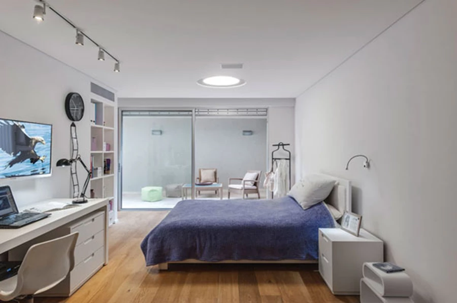 חדרה של הבת בקומת המרתף נהנה מאזור חוץ פרטי שמייצרת חצר אנגלית.