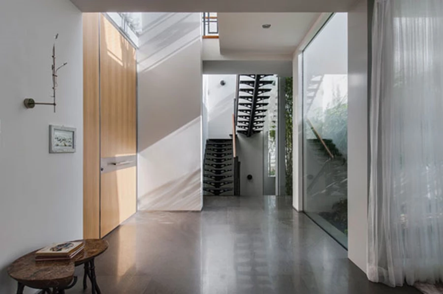 מבואת הכניסה לחלל הפנים: קיר ופטיו חיצוני מגדירים הפרדה ברורה בין האזור הציבורי והאזור הפרטי הממוקמים משני עבריהם.