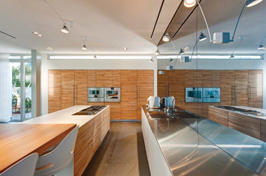 המטבח: תחום בין קיר מראה לבין יחידת אי, מעניק קשרי עין ישירים עם החוץ ומשלב עץ אגוז... וזכוכית לבנה. יחידת הכיור צמודה לקיר המראה ממנו מגיחים גופי תאורה מעודנים, ויחידת קיר מרשימה על טהרת השימוש בעץ נוסכת נוכחות חמימה. מטבח: פנומנה (TEAM7), אביזרי מטבח: תותחני בע