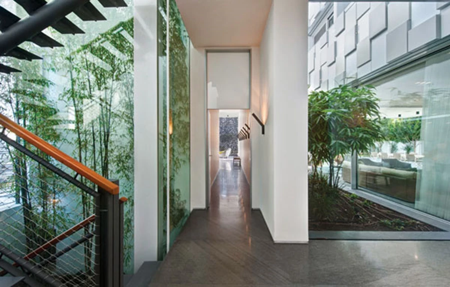 המעבר ליחידת ההורים הממוקמת מעברו השני של הקיר התוחם את הפטיו החיצוני, מופרדת לחלוטין מהחלל הציבורי. בעומק נראית חצרה הפרטית, ומשמאל פטיו פנימי שמלווה את גרם המדרגות ומחדיר נוף צמחייה ירוקה שנשתלה בתוכו.   מוצרי יוקרה ואביזרי פנים: קליינס