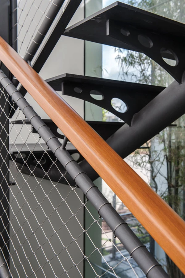 גרם המדרגות: קונסטרוקציית ברזל ומדרכי ברזל מעוצבים כמשולשים מעודנים בחיתוך לייזר. המעקה משלב מאחז יד עשוי עץ ומסגרת מפרופילי ברזל עגולים שבתוכה, אך במנותק ממנה, אחוזה רשת מתכת