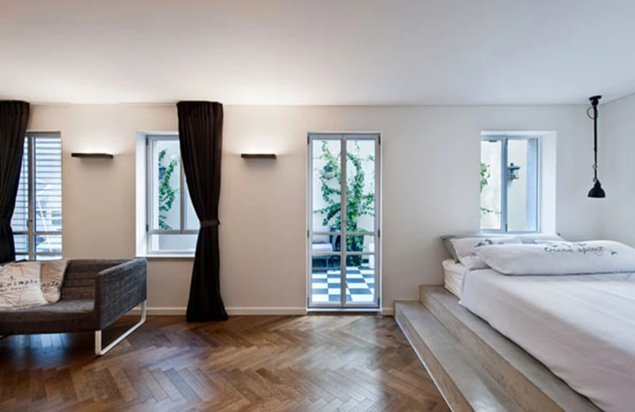 בחדר הבן: מיטה כבמה יצוקה מבטון עם שתי מדרגות שיכולות לתפקד כספסלים/מדפים.