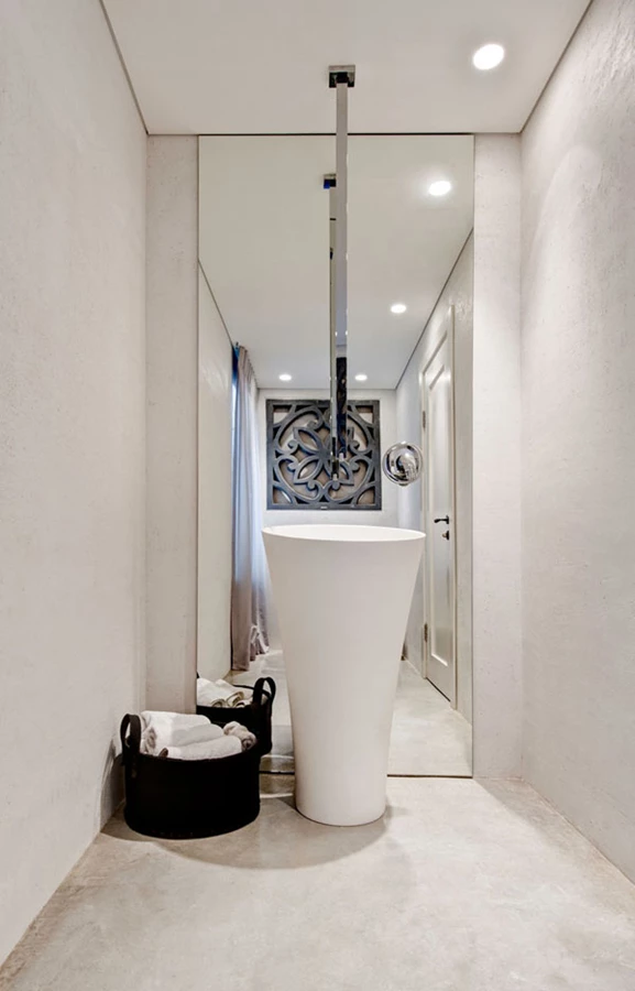 שירותי האורחים: סגנון לפרטי פרטים. מראה מרצפה לתקרה כרקע לכיור קוריאן פרי סטנדינג וברז שמוצאו בתקרה. בתוך גומחה משתלבת משרבייה עשויה בטון.