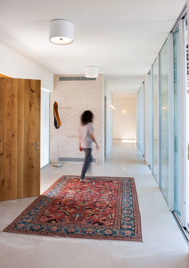 בכניסה לחלל הפנים: רצף ויטרינות מייצר חזית שקופה הפונה אל החצר הפנימית ומאפשרת להישיר מבט אליה ואל נוף השדות המשתרע מעבר לה.