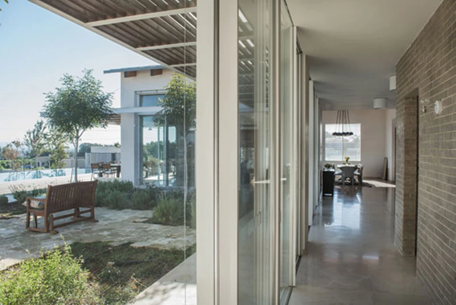 מעבר שקוף לאגף החדרים מחזק קשרי חוץ ופנים. ריצוף אבן שיש 