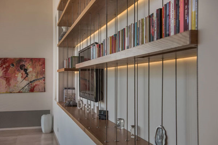 גומחה שתוכננה ייעודית כפרט עיצובי: בתוכה משתלבים מדפים תלויים על כבלי מתכת עם שילוב תאורה תחתיהם, תוך יצירת חזות של מעין תמונה.