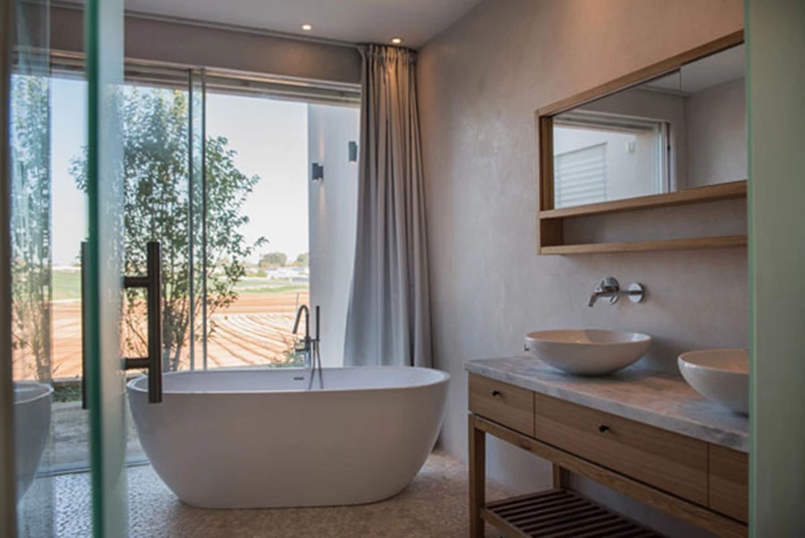 חדר הרחצה ביחידת ההורים: תחום בוויטרינה גדולה הפונה אל פטיו חיצוני ומוצנע ע