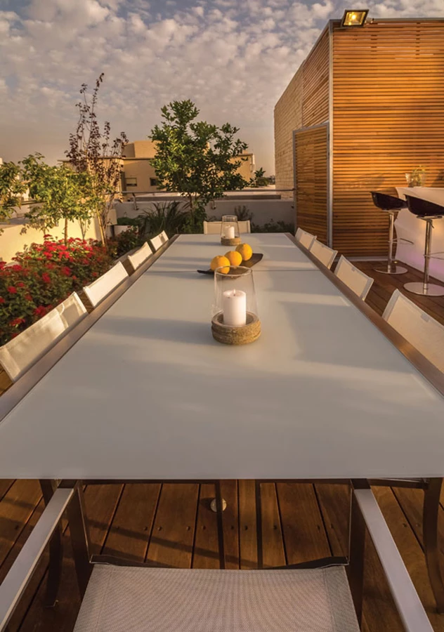 פינת האוכל: גדולה דיה להכיל בנוחות עשרה סועדים. ברקע: קוביית סרגלי עץ סידר המשמשת לאחסון אביזרים טכניים ו