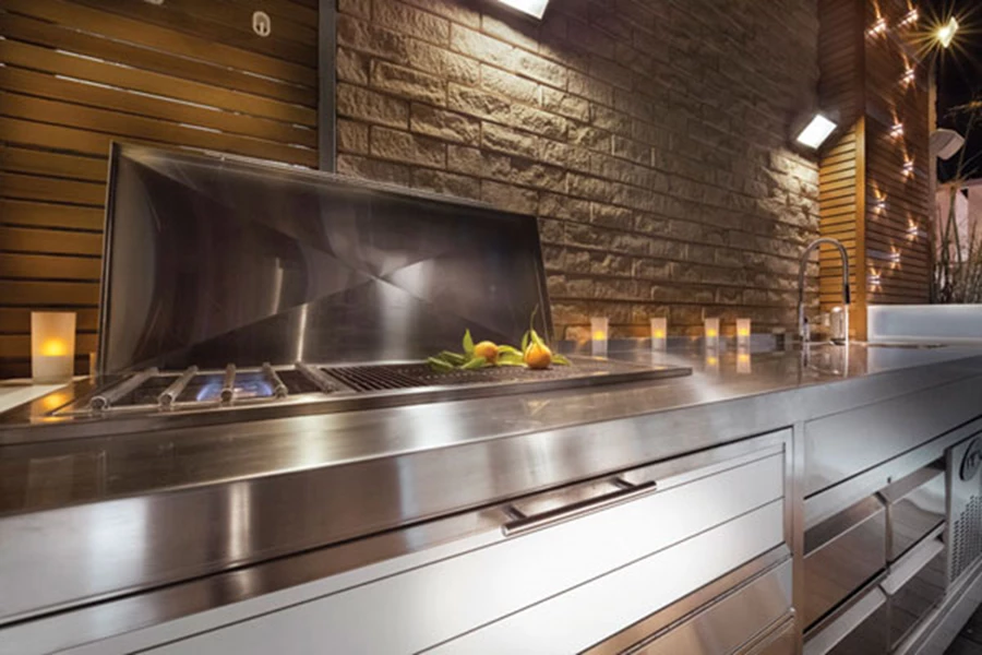 דבר לא חסר לבישול ארוחת גורמה: מטבח שתוכנן ייעודית וכולל את כל פונקציות הבישול הנדרשות. משלב גוף ומשטחים מנירוסטה ודלתות ואקום עם חיפוי חומר פלסטי דחוס מתאים לסביבת חוץ.(HPL). על הקיר: גופי תאורה טכניים. מטבח: ווינטר מערכות גז.