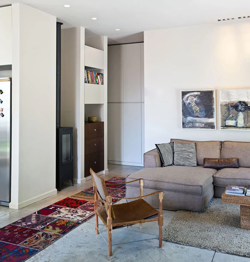 מעבר מהחלל הציבורי אל אזור החדרים. גומחה ייעודית מאכלסת בתוכה אח ברזל יצוק ופונקציות אחסון שונות.