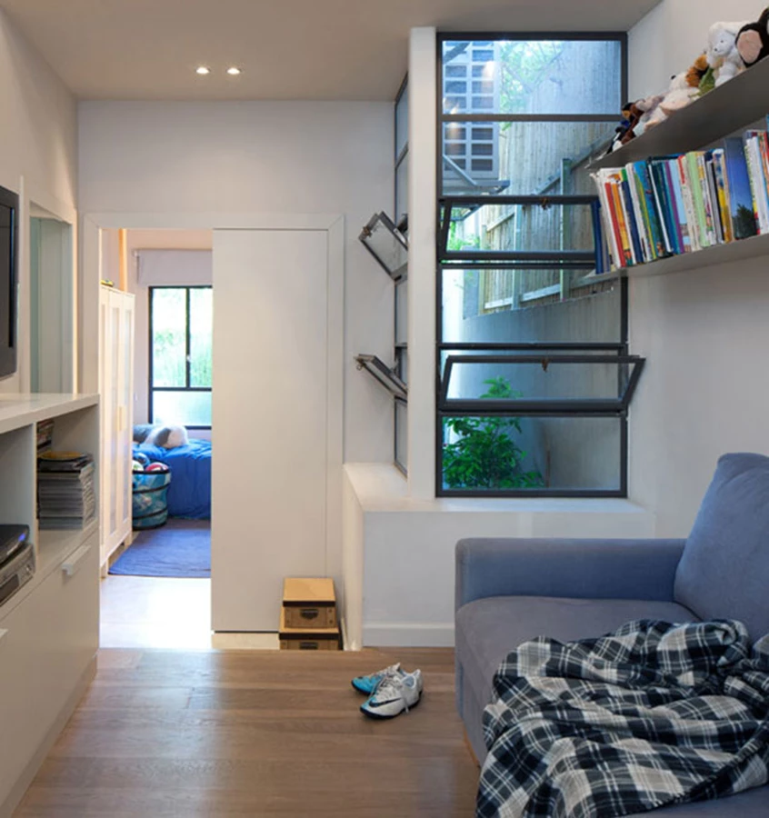 פינת טלוויזיה-מחשב באזור החדרים הוארה ואווררה באמצעות פריצת פתחים חדשים מותקנים במסגרות פרופיל בלגי.