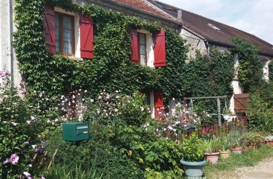 חזית הבית והחלונות הצבעוניים-מהווים חלק משמעותי ממראה הגן.