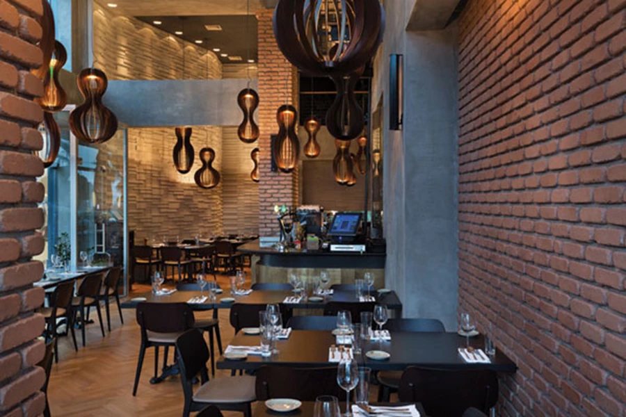 האזור הפנימי: חיפוי בלוחות עץ נפחיים וגופי תאורה המרככים את ממד הגובה הכפול וכמו מייצרים מפלס גובה נוסף המעניק קנה מידה אנושי.