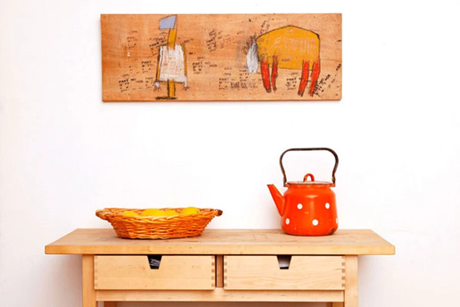 ציור נאיבי, של האמנית דליה סלע, על דיקט ממוחזר שהיה חלק מארגזי משלוח - מעצים את התמימות הכפרית בפינת המטבח צילום- גלעד וולפין