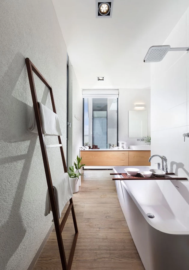 קפידה וסגנון באזור הרחצה של יחידת ההורים: חיפוי קיר באריחים אפורים המהדהדים מראה בטון, יחידת כיור מרחפת מעץ, ואביזרים סניטאריים עשויים קוריאן. אביזרים סניטאריים ואביזרים משלימים: