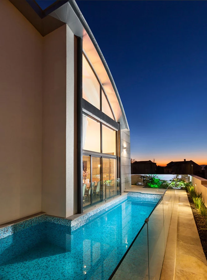 הבריכה שבחזית האחורית צמודה אל המבנה וזורמת עמו בקו אורכי.