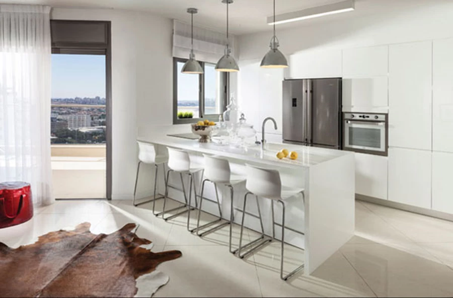 המטבח: עיצוב נקי ומינימליסטי בגון לבן וחזיתות בגימור צבע מבריק בתנור. יחידת קיר משלבת בתוכה מכשירי חשמל, ויחידת אי שמשמשת גם כדלפק אכילה עם משטח אבן קיסר בו מותקנים הכיריים וכיור הומוגני. מטבח: