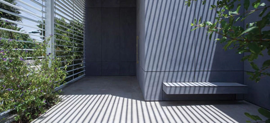 ספסל שמשתלב בתוך קיר החזית וכמו מגיח מתוכו לרגע של אתנחתא לפני הכניסה פנימה וכמקום מפגש לילדים וחבריהם.