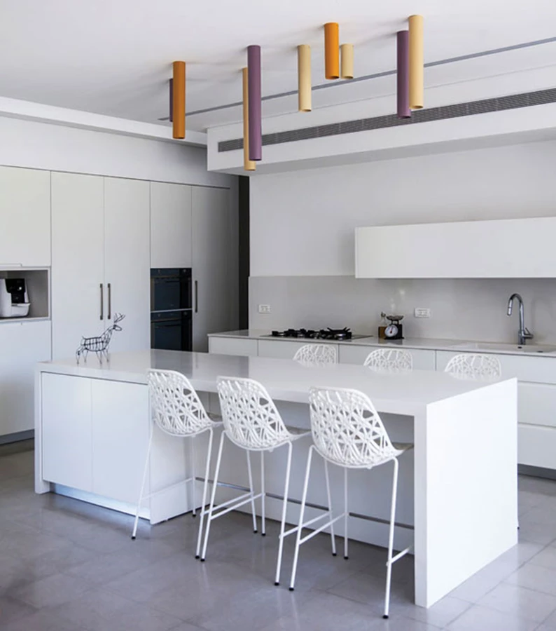 המטבח: מרווח ומעוצב בשפה נקייה המשלבת יחידת אי שמתפקדת גם כדלפק אכילה, יחידת כיור ויחידת קיר גדולה במיוחד בה משתלבים מכשירי החשמל המשטחים עשויים אבן קיסר, החזיתות בגימור צבע בתנור, ואת יחידת האי מלווה ממעל קומפוזיציית גופי תאורה מעוצבים כצילינדרים צבעוניים באורכים שונים. מעל יחידת הקיר סקיילייט המחדיר אור יום גם ממעל. מטבח: