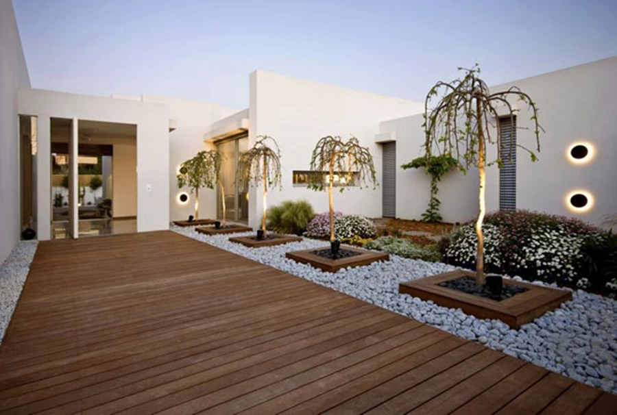 גופי התאורה על רחבת הכניסה מסמנים הילה נעימה ומאירים את גזעי העצים שעומדים לפניהם צילום-מושי גיטליס