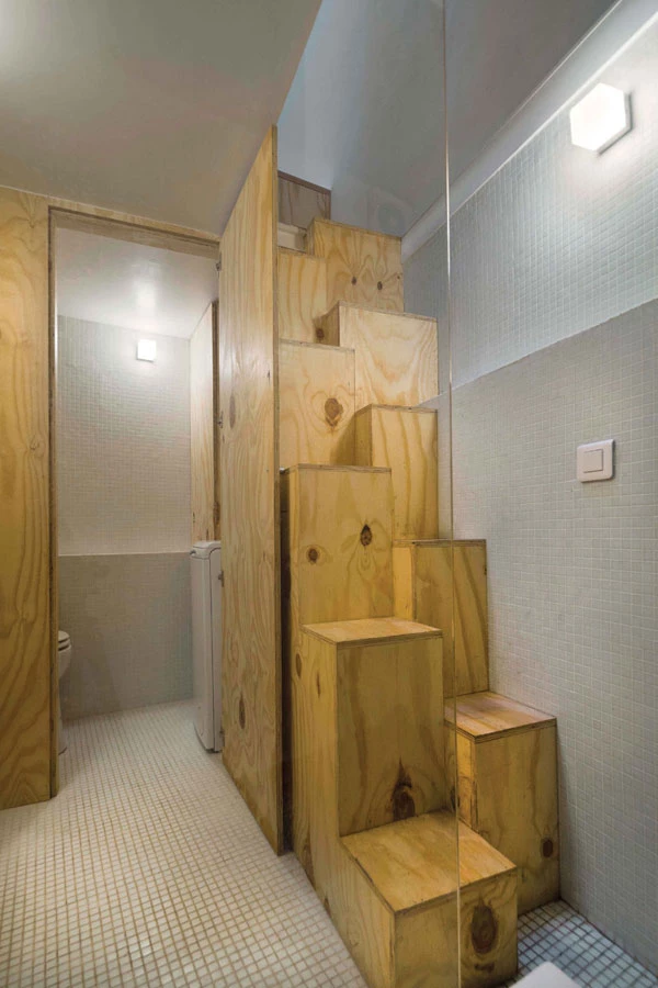 מדרגות מעוצבות כמקבץ קוביות עץ מובילות לקומה השנייה.