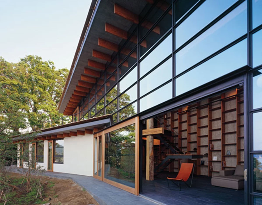 מבט אל תוך החלל הציבורי. הקורות המייצרות את היחידות הופכות במרחב הפנים לספרייה שמלווה את כל אורכו של הקיר מרצפה לתקרה. ריצוף באריחי צפחה שחורים.