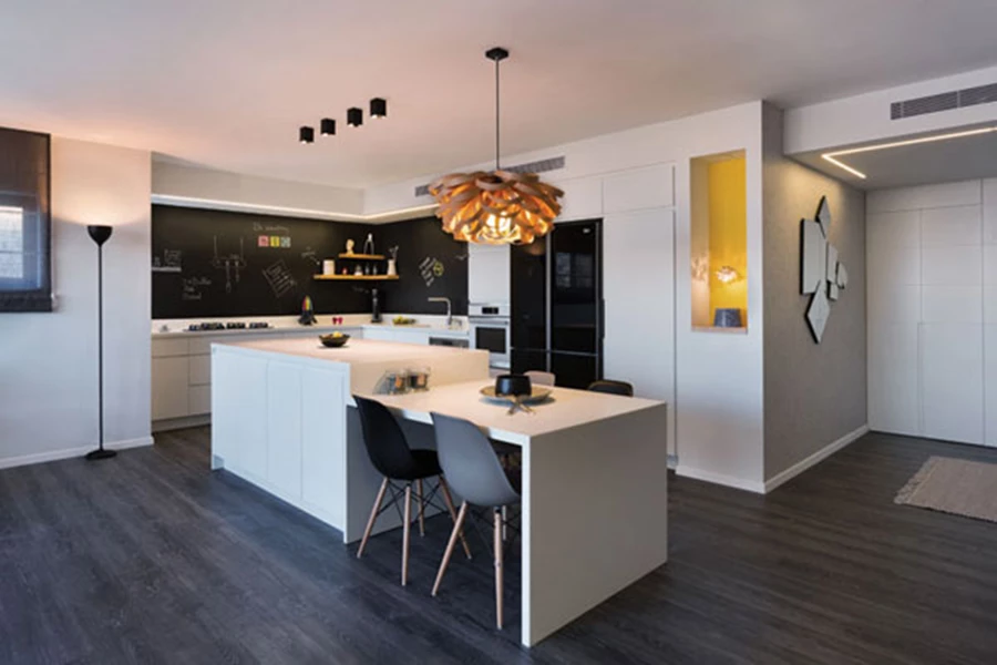 המטבח: חזיתות לבנות, משטחי העבודה ויחידת האי מקוריאן, וחיפוי קיר בטפט המדמה לוח שחור עליו ניתן לכתוב. יחידת האי הגדולה משמשת גם כשולחן אוכל: בעת הצורך ניתן להצמיד אליה שולחן ולחבר אותם למשטח ארוך דיו לאירוח נוח. גוף התאורה המסוגנן שמשתלשל מעל מעוצב מפורניר עץ.  כסאות מטבח: 