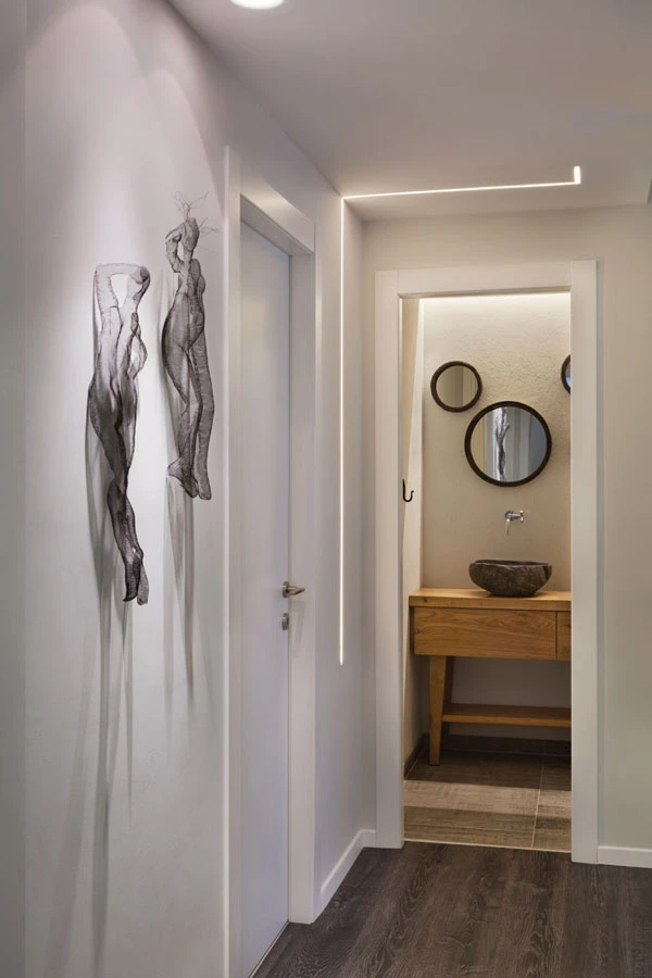 עניין מוקפד בכל פינה:  קיר צהוב, עבודות אמנות ופסי תאורה מעשירים את חלל המעבר.