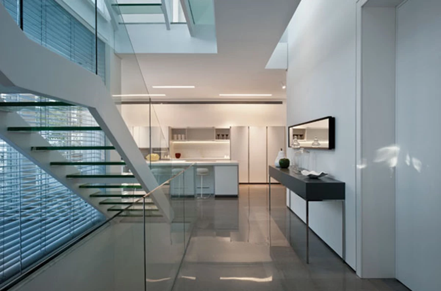 קומת הכניסה וחלל המדרגות המגדיר את חלוקת אזוריה: סלון ופינת אוכל מעברו האחד ומטבח מעברו השני. מטבח: בולטהאופ, תאורה: אקסקלוסיבי, ריצוף באריחי שיש שייגרי אפורים: שיש רוקח.