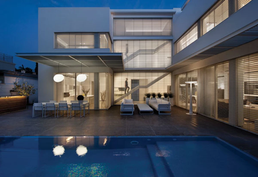 החזית האחורית: חובקת גינה מטופחת עם בריכת שחייה ופינות אוכל וישיבה, וגרם המדרגות הנחשף מבעד קיר המסך מאציל את נוכחותו הדומיננטית גם על החוץ.  בריכות (קדמית ואחורית): אקווהפולקו, פרגולה: עמיאל תעשיות מקבוצת אלוקל.