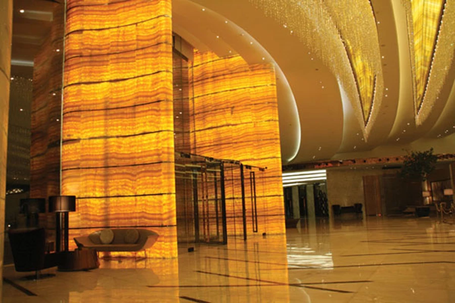 בלובי: גופי תאורה המשתלשלים מתקרת האבן הצהובה-כתומה מעוצבים תוך שילוב 20.000 אבני סברובסקי  קטנות התלויות בצורה גלית שמאזכרת את תנועת גלי המים.