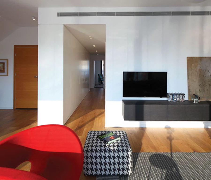 קומת הכניסה: מבט אל הסלון ששטחו גדל עם העתקת המטבח אל הקומה העליונה. ריצוף פרקט ועיצוב מודרני בו משתלבות נגיעות צבעוניות חמימות. ריהוט ושטיח: