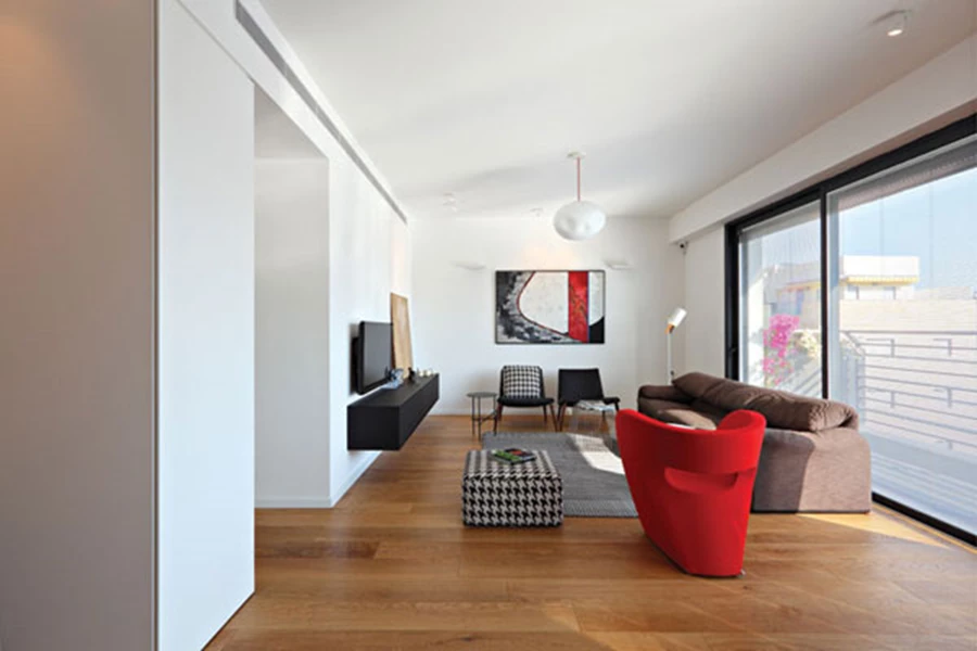 מבט מעומק הסלון אל גרם המדרגות: תחושת רווחה ואווריריות. החלל מתחת גרם המדרגות מנוצל לשמש כפינת עבודה נוחה. נגרות: לייבל נגרות בע