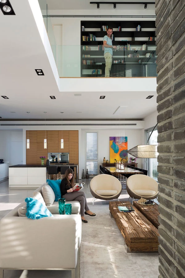 מבט מאזור הכניסה אל עבר כלל אזורי החלל ואל הספרייה הממוקמת בגשר- הגלריה שבקומה העליונה. ריצוף באריחי שייגריי אפורים המדמים בטון, קירות לבנים, ותאורה המשלבת גופים שקועים עם גופים דקורטיביים ממוקדים.