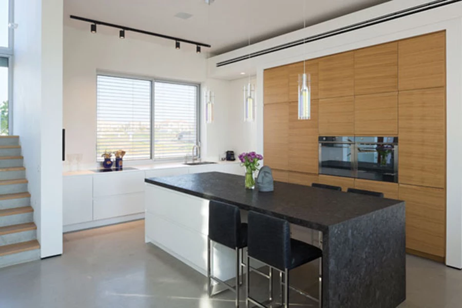 המטבח: רווחה ונגישות נוחה לפינת האוכל. יחידת כיור עם משטח קוריאן, יחידת קיר עם חזיתות פורניר מחורץ מצניעה בתוכה מכשירי חשמל אינטגראליים, ויחידת אי גדולה עם משטח גרניט כמו מגדירה את החלל במרחב הפתוח. מטבח: