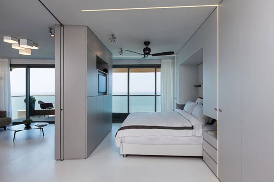 יחידת נגרות דו צדדית בגימור אפור מט חוצצת בין אזורי הסלון והשינה ומשרתת את שניהם לתליית מסך הטלוויזיה ולאחסון מערך האודיו-וידאו. צדה הפונה לאזור השינה מכיל גם אזורי אחסון ייעודיים, ובכלל זה שתי מיטות נשלפות המצוידות בגלגלים לניוד קל. נגרות: