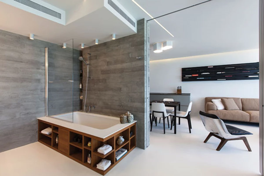 אזור השינה והאפשרויות השונות כשהמחיצות סגורות/פתוחות. האמבט העשוי קוריאן תחום במעטפת עשויה עץ טיק שתוכננה ייעודית עם דפנות המכילות תאי אחסון נוחים למוצרי טואלטיקה.