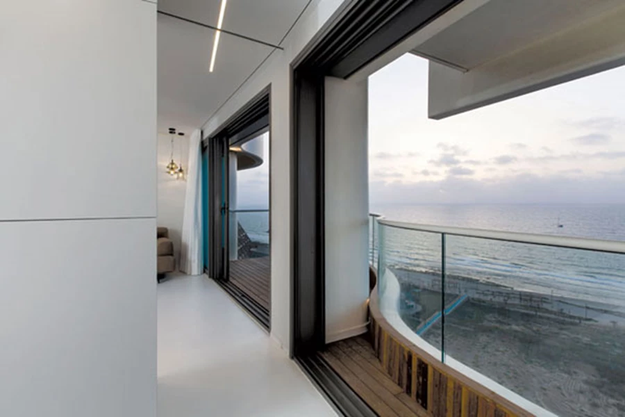 המרפסת המתעקלת קלות מרוצפת בדק עץ, וכמו מותחת את גבולות החלל לכיוונה תוך תחושה של המשכיות. תכנון מרפסת: