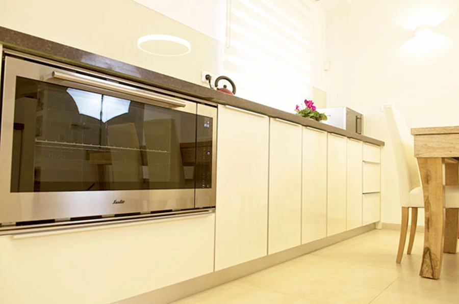 במטבח הדגשנו את המראה האוורירי באמצעות ארונות עם ידיות עיליות שמקנות לדלתות מראה נקי ונטול הפרעות