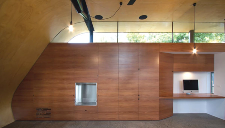 חדר המגורים ואזור המחשבים / טלוויזיה המחבר את שני המבנים. בחוץ נראה נוף העצים של הבית השכן.