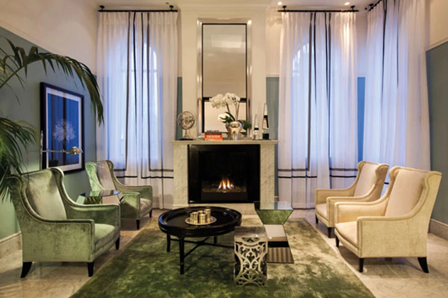 אזור הישיבה בלובי: יוקרה אלגנטית וחזות של סלון ביתי לכל דבר. טקסטילים עשירים כמשי וקטיפה, קמין המשווה חמימות ופריטי ריהוט ואמנות שנבחרו בקפידה.