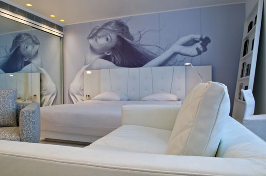 הדמות המצולמת שמשתלבת במדויק מעל המיטה יוצקת נופך של