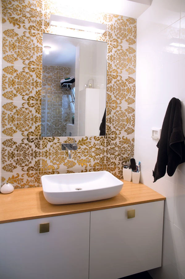 חדר רחצה של חדר שינה: אריחי חיפוי זהובים, יחידת כיור שעוצבה ייעודית וכיור מסוגנן משדרגים את המפרט הסטנדרטי | כלים סניטאריים: