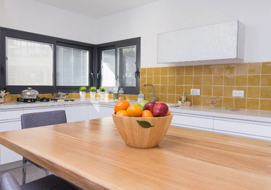 השימוש בעץ ומתכת הם מוטיב חוזר בבית המתכתב עם המטבח והסלון.