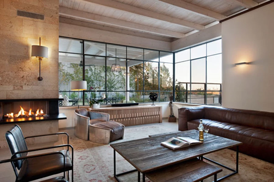 הסלון שבעומק החלל צופה אל האופק ומאופיין בעיצוב חמים ואינטימי השם דגש על כנות החומר ועל גימורים טבעיים. | גופי תאורה: קמחי תאורה | ויטרינות פרופיל בלגי: יבגני, 100 פלוס