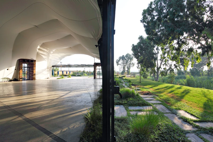 דיאלוג צפוף בין פנים וחוץ: לטובת יצירתו ננגס שטח מהחלל, כך שהגינה כמו פולשת לתוכו. בתוך המבנה: ממבראנה נעה שנועדה לחולל תנועת שינויים בחלל- יריעת ענק של בד גיאו-טכני אלסטי שבתוכה מושחלים צינורות CVP בתצורת קשתות. ביצוע הממבראנה: “מילגה”