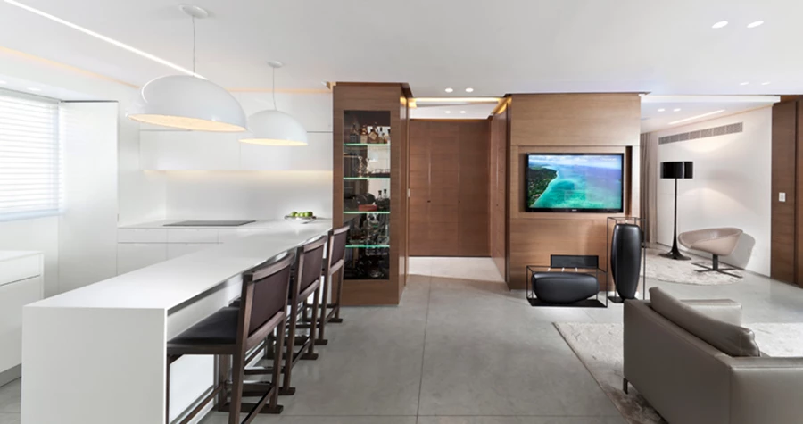 מבט מכיוון הכניסה: חלל קריא, פתוח ומוגדר כאחד, ורצף חומרי המחזק תחושת זרימה. אלמנט עשוי עץ בו משתלבות מחיצות הזזה מנוצל מכל עבריו למילוי פונקציות שונות בכל צד אליו הוא פונה.