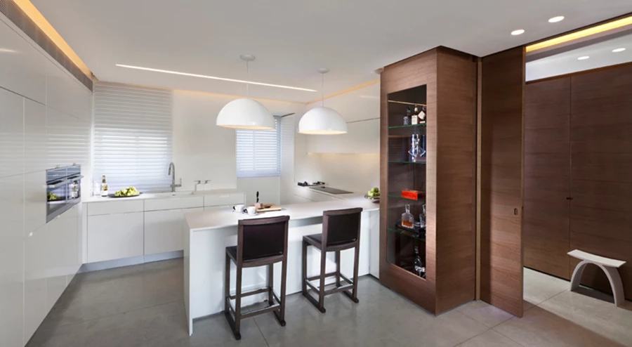 המטבח המעוצב על טהרת השימוש בקוריאן ובסמוך אליו כניסה לחדר השינה שעוברת דרך מבואה קטנה. יחידת הנגרות בה משתלבת מחיצת ההזזה המפרידה בין שני החללים “מעובה” בשטח המטבח לכדי ויטרינה שימושית ונאה. נגרות מטבח: Jonathan