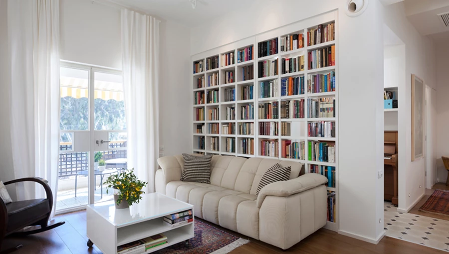 ספרייה כאלמנט חוצץ בין פינת הפסנתר הממוקמת בקצה השדרה, לבין חלל הסלון: תוחמת ומגדירה כאחד, ומעניקה קשר ויזואלי מרומז מאידך.