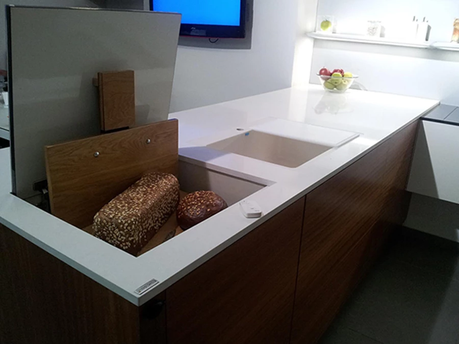 מדף אלקטרוני מתוחכם המתרומם מתוך ארון המטבח ומופעל באמצעות שלט ומסתיר פריטים שאינם בשימוש. 